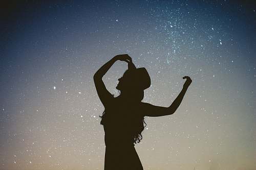 people silhouette of woman holding hat in blue and gray nebula woman