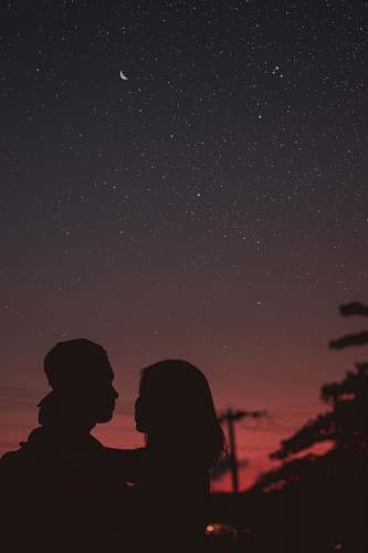 person silhouette of woman hugging mna under starry night sky human