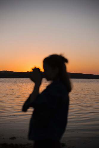 nature silhouette of woman near body of water outdoors