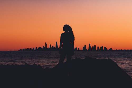 human silhouette of woman near shoreline people