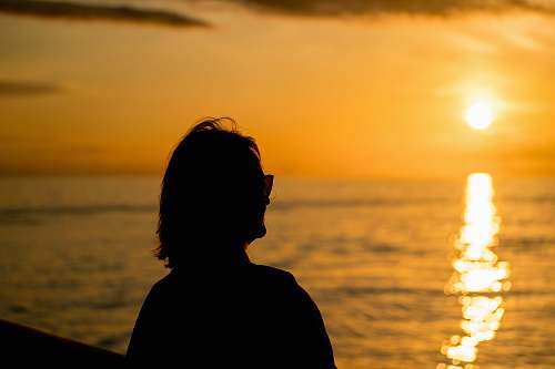 person silhouette of woman standing facing sunset human