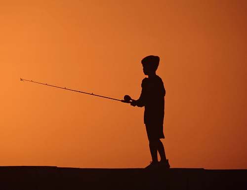 human silhouette photo of boy fishing during sunset people