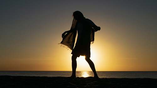 nature silhouette photo of person wearing black scarf outdoors