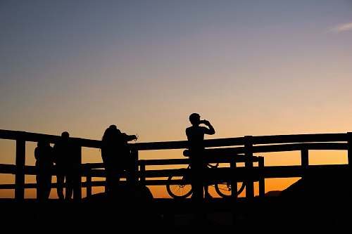 people silhouette photo of persons taking photo of sunset person