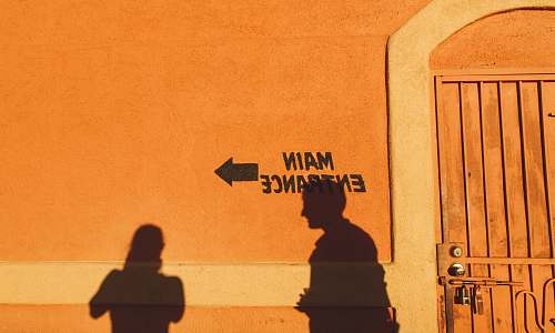 door silhouette photo of two person reflecting on orange painted wall with main entrance print tucson
