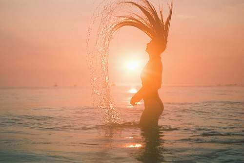 beach silhouette photo of woman against sunlight ocean