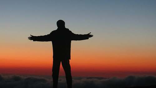 human silhouette photography of man spreading his arms on air person