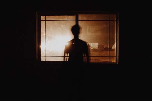 light silhouette photography of person in front of window window