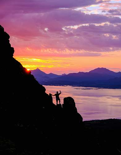 nature silhouette photography of person standing on cliff outdoors