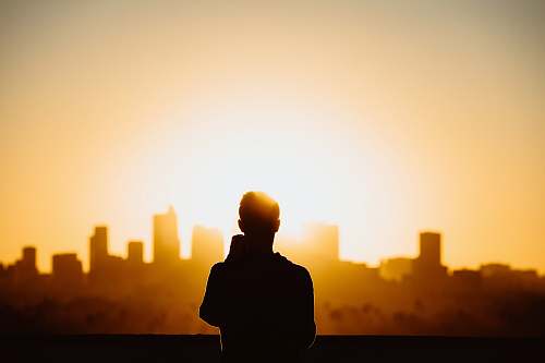 person silhouette photography of standing person during sunset human