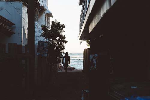 alley Surfer walking through the alley towards the ocean beach
