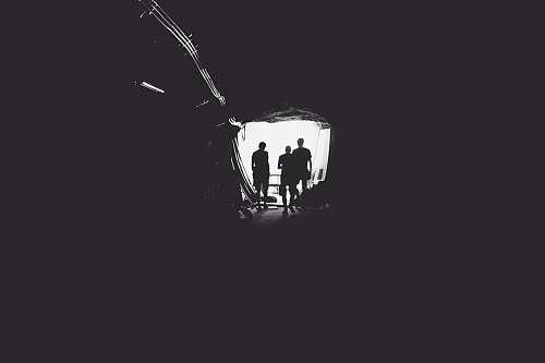 black-and-white three person standing in tunnel tunnel