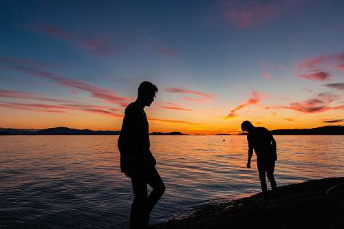 person two men standing beside body of water human