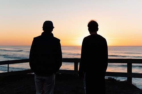 person two men standing beside sea human