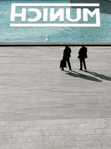 munich two person standing near body of water barcelona