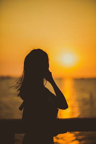 person woman beside railing during golden hour human