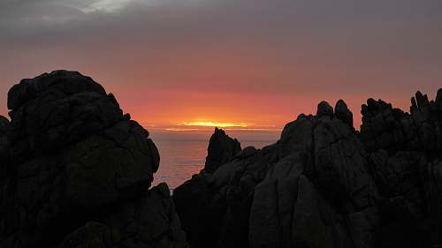 sunset brown cliff near body of water at sunset rock