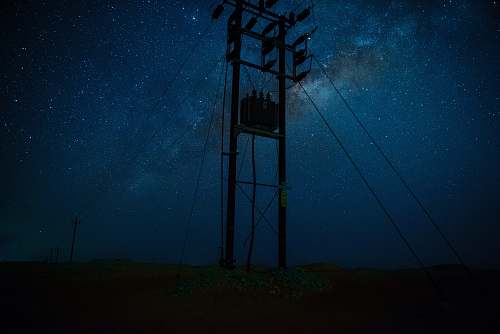 blue silhouette photography of post during starry night cable
