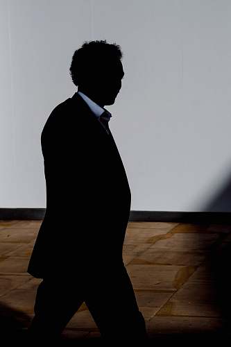 clothing silhouette of man walking inside room overcoat