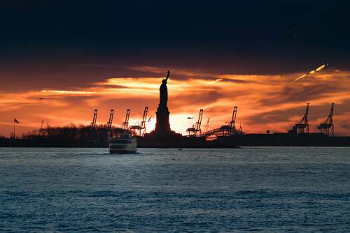 sunrise silhouette of Statue of Liberty near body of water river
