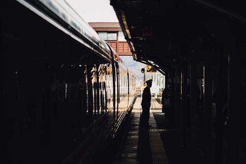 train man standing near train in subway during daytime train station