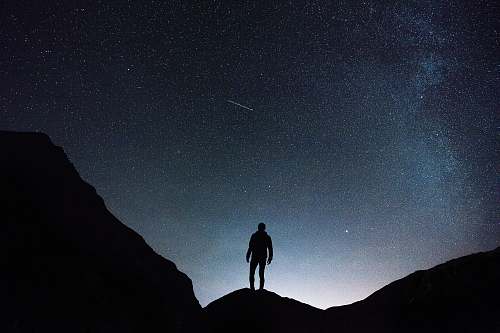 night silhouette of man standing on hill during starry night desktop wallpapers