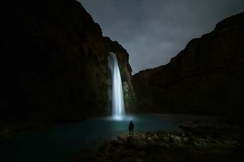 waterfall person standing on the ground staring the waterfalls havasu falls