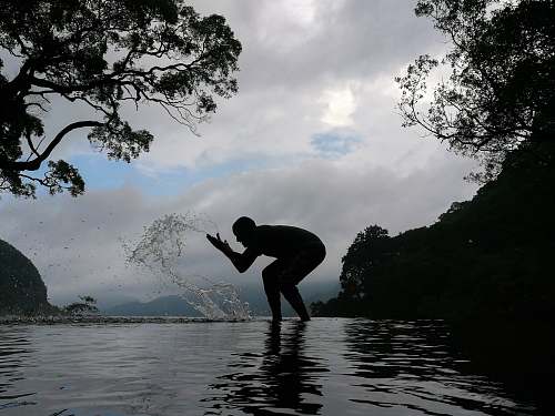 human silhouette of person splashing water person