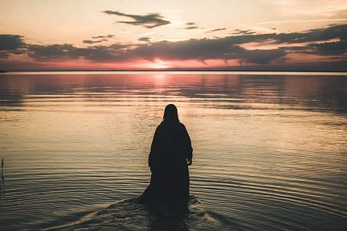 outdoors woman walking in sea during golden hour nature