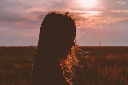 field silhouette photo of a woman grass
