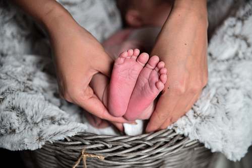newborn person holding baby's feet kid