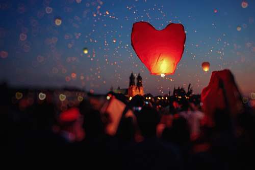people crowd of people flying heart lanterns in the sky ball