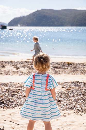 ocean girl wearing white and blue cap-sleeved shirt dress near beach sea