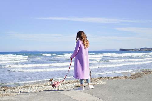 ocean person in purple trench coat near body of water sea