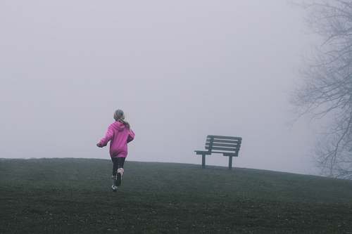 child girl running near black bench running