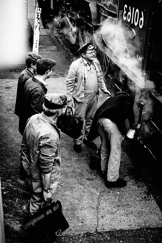 person grayscale photo of men standing beside 60163 train people