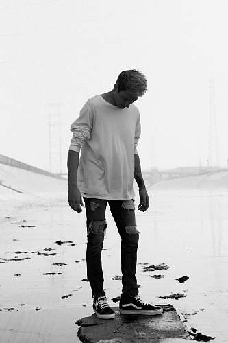 person man wearing boat-neck long-sleeved shirt and distressed jeans people