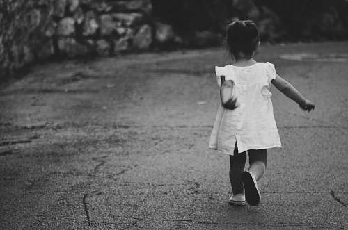 black-and-white gray scale photography of girl walking towards destination kid