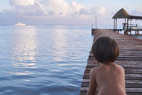 person boy kneeling on wooden dock people