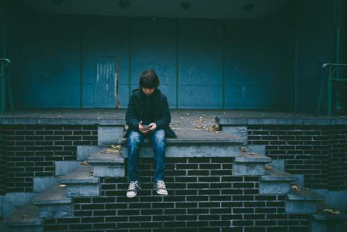 people boy sitting on concrete stairs person