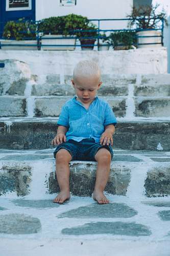 person boy sitting on gray concrete stair people