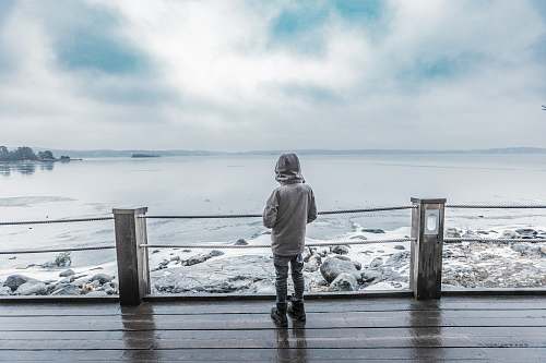 people child standing infront of seashore on brown platform person