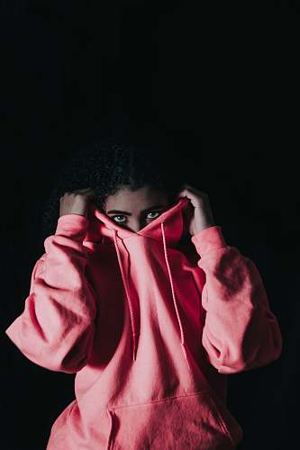 people girl wearing pink pullover hoodie covering her nose person