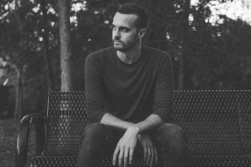 people grayscale photography of man wearing long-sleeved shirt black-and-white