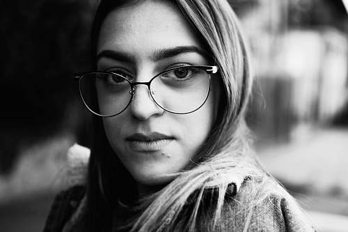 people grayscale photography of woman with eyeglasses black-and-white