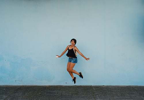 people jumping woman on gray ground under white cloud blue skies person