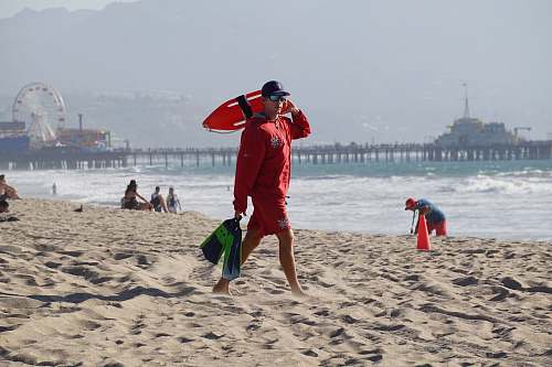 beach lifeguard walking in a sand shore ferris wheel