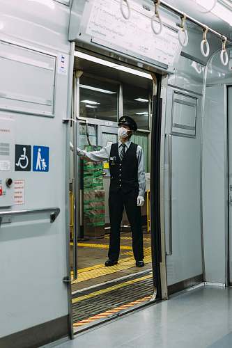 people male guard in black and white dress standing infront of train station person