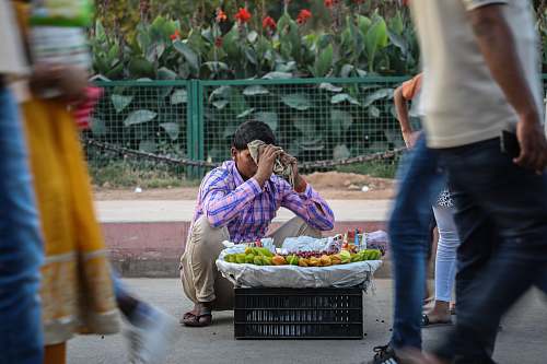 people male vegetable vendor at street during daytime person