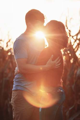 people man and woman kissing during golden hour person